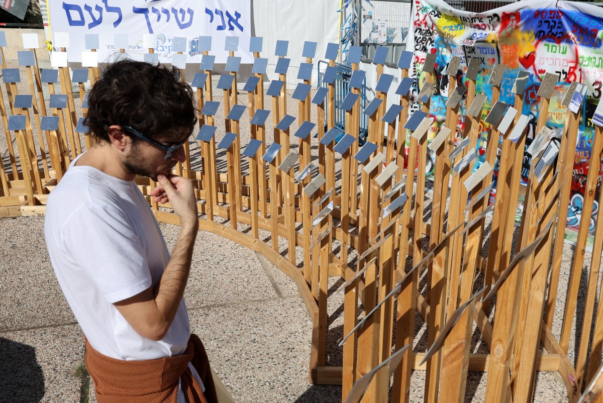 Un homme regarde une installation à Tel Aviv portant les noms des personnes prises en otage par les militants palestiniens du Hamas lors de l'attaque du 7 octobre, le 24 novembre 2023, quelques heures après le début d'une trêve de quatre jours dans les batailles entre Israël et le Hamas. (Photo Jack Guez AFP)