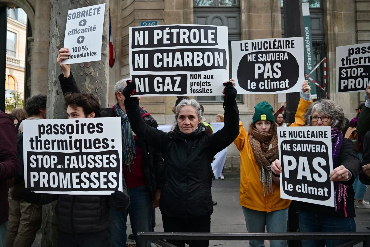 Des manifestants tiennent des pancartes lors d'une action à l'appel de plusieurs organisations environnementales pour dénoncer les choix énergétiques du gouvernement devant le ministère de la transition écologique à Paris le 6 novembre 2023. (Photo de Miguel Medina AFP)