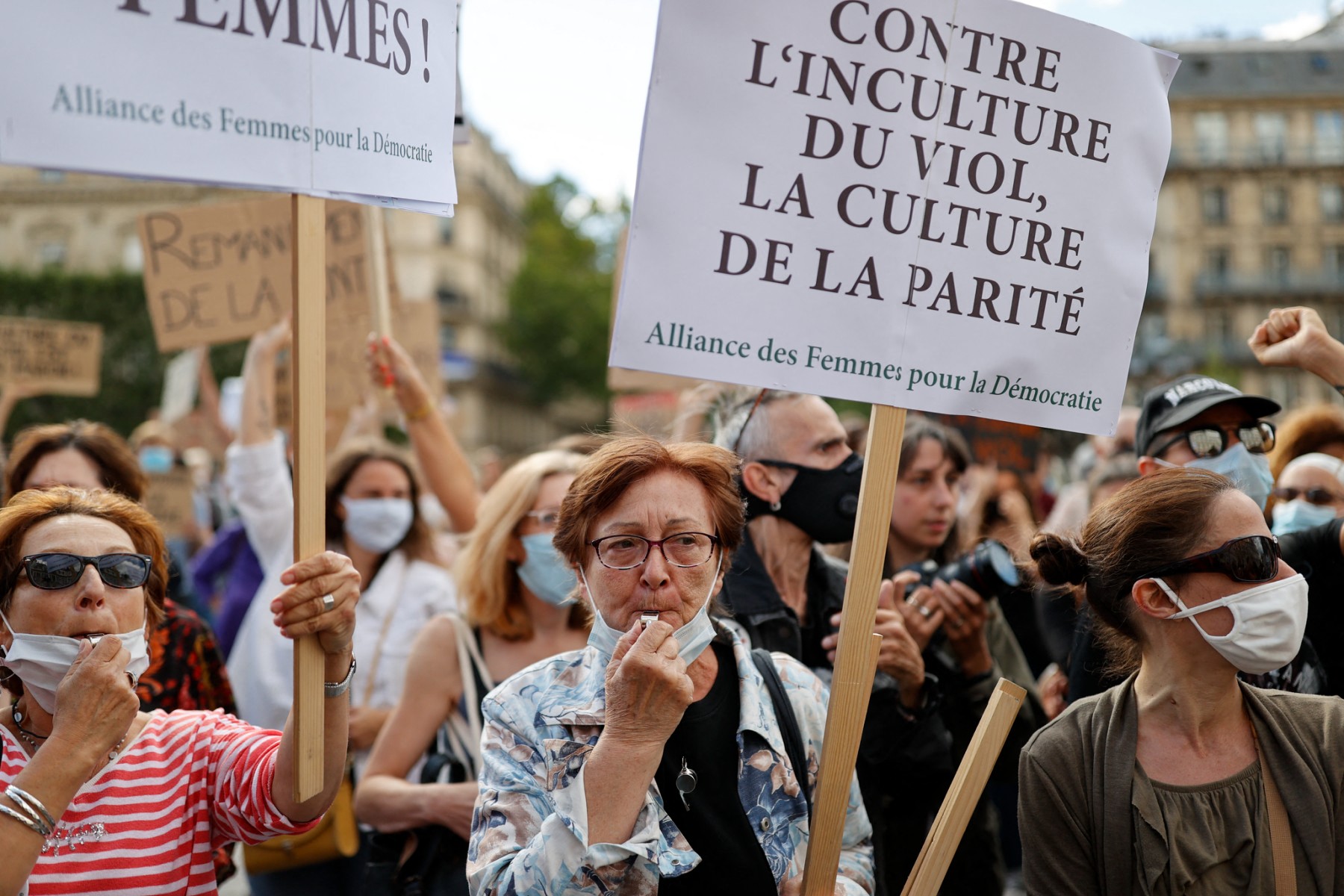 Une manifestante munie d'un sifflet tient une pancarte sur laquelle on peut lire "contre l'ignorance du viol, la culture de la parité" lors d'une manifestation à l'appel de mouvements féministes devant l'hôtel de ville de Paris, le 10 juillet 2020, pour dénoncer la nomination du ministre français de l'Intérieur, confronté à des accusations de viol, et de la ministre française de la Justice qui a critiqué le mouvement #MeToo contre le harcèlement sexuel. (Photo de Thomas Coex AFP)