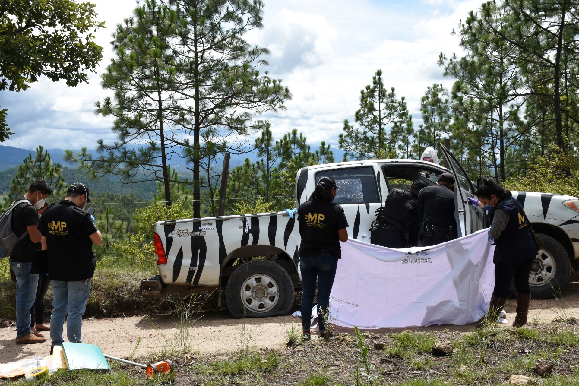 Des policiers et des membres du ministère public recherchent des preuves sur le site où le défenseur français des droits de l'homme Benoît Maria a été tué à San Antonio Ilotenango, au Guatemala, le 10 août 2020. (Photo Nuestro Diario AFP)