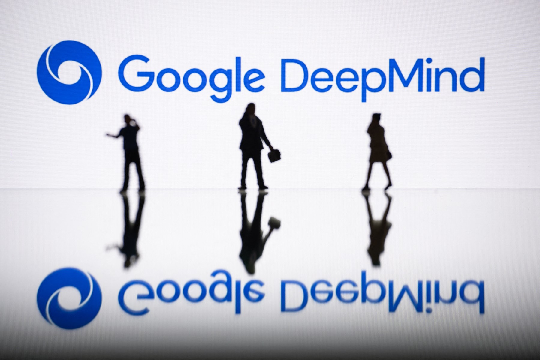 Cette photo d'illustration prise le 30 octobre 2023 à Mulhouse, dans l'est de la France, montre des figurines à côté d'un écran affichant un logo de Google DeepMind, un laboratoire britannico-américain de recherche sur l'intelligence artificielle. (Photo Sebastien Bozon AFP)