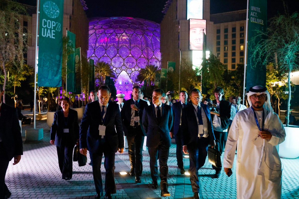 Le président français Emmanuel Macron (au centre) quitte le lieu des réunions bilatérales en marge du sommet climatique des Nations unies COP28 à Dubaï, le 1er décembre 2023. (Photo Ludovic Marin AFP)