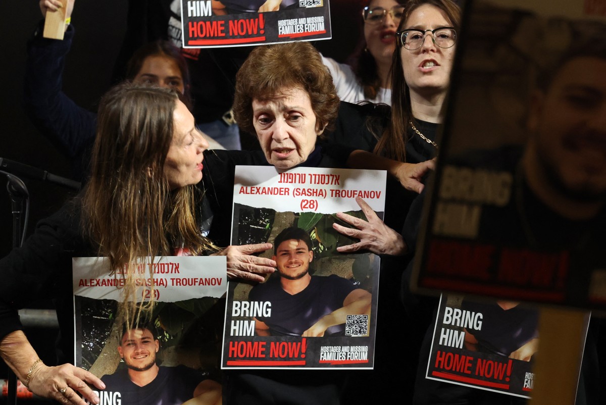 L'ancienne otage russo-israélienne Irena Tati (au centre) tient une photo de son petit-fils Alexander (Sasha) Tropanov, âgé de 27 ans, lors d'une manifestation à Tel Aviv le 2 décembre 2023, appelant à la libération des otages israéliens détenus à Gaza depuis les attaques du 7 octobre. (Photo Ahmad Gharabli AFP)