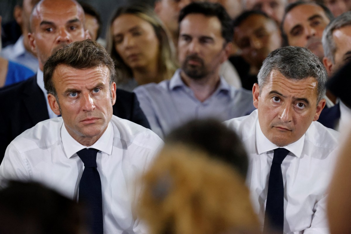 Le président français Emmanuel Macron (à gauche) et le ministre français de l'Intérieur Gerald Darmanin écoutent un participant alors qu'ils assistent à une réunion publique avec des habitants dans un gymnase du quartier de La Busserine lors d'une visite à Marseille, dans le sud-est de la France, le 26 juin 2023.. (Photo Ludovic Marin, POOL AFP)