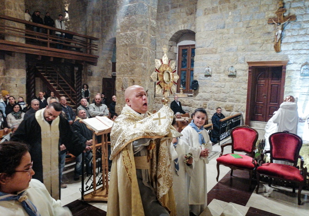 Un prêtre dirige la messe dans une église du village de Qlayaa, à la frontière sud d'Israël, le 21 décembre 2023, dans un contexte de tensions transfrontalières, alors que les combats se poursuivent entre Israël et les militants du Hamas à Gaza. (Photo par AFP)