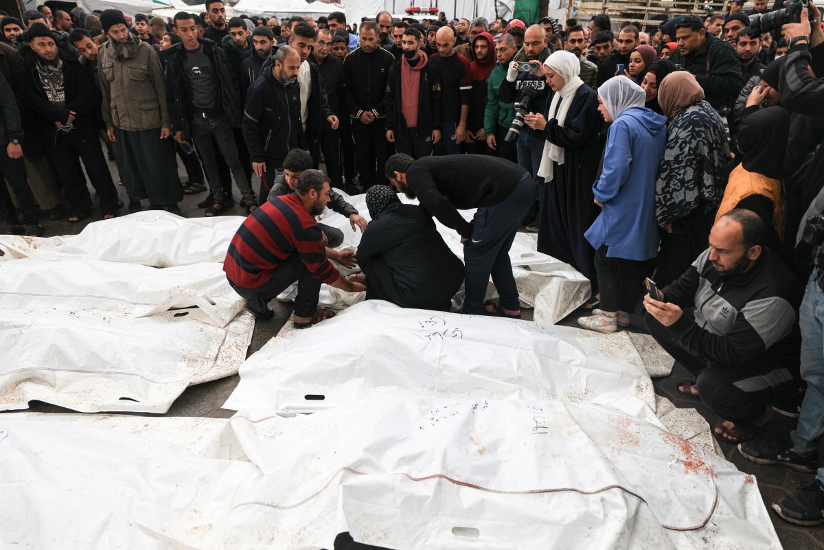Des Palestiniens pleurent leurs proches, tués lors d'une frappe israélienne sur le camp de réfugiés d'Al-Maghazi, lors de funérailles collectives à l'hôpital Al-Aqsa de Deir Al-Balah, dans le centre de la bande de Gaza, le 25 décembre 2023, alors que les combats se poursuivent entre Israël et le Hamas. (Photo de Mahmud Hams AFP)