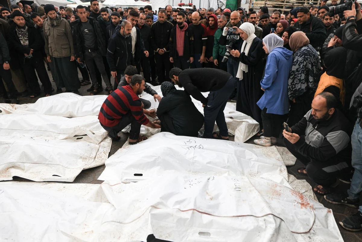 Des Palestiniens pleurent leurs proches, tués lors d'une frappe israélienne sur le camp de réfugiés d'Al-Maghazi, lors de funérailles collectives à l'hôpital Al-Aqsa de Deir Al-Balah, dans le centre de la bande de Gaza, le 25 décembre 2023, alors que les combats se poursuivent entre Israël et le Hamas. (Photo de Mahmud Hams AFP)