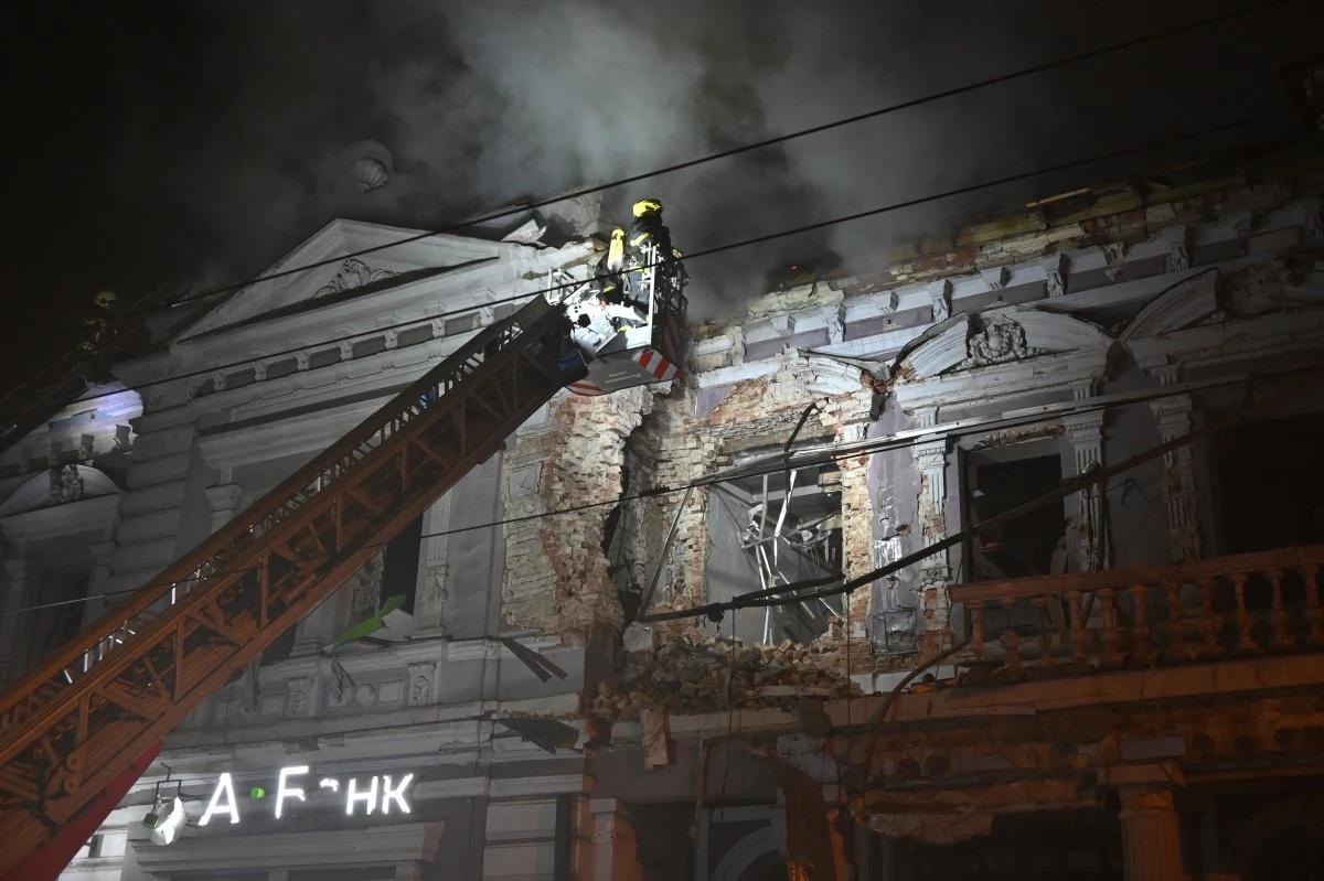 Un pompier sur une grue combat un incendie dans un bâtiment après une attaque de drone russe à Kharkiv, le 31 décembre 2023, dans le cadre de l'invasion russe de l'Ukraine. (Photo de Sergey Bobok AFP)