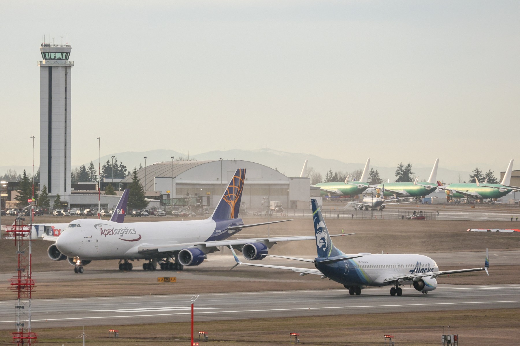 Un Boeing 737-800 d'Alaska Airlines, à droite, décolle alors que le dernier 747 produit par Boeing, un 747-8 Freighter pour Atlas Air, roule avant de décoller de Paine Field à Everett, Washington, le 1er février 2023. (Photo Jason Redmond AFP)