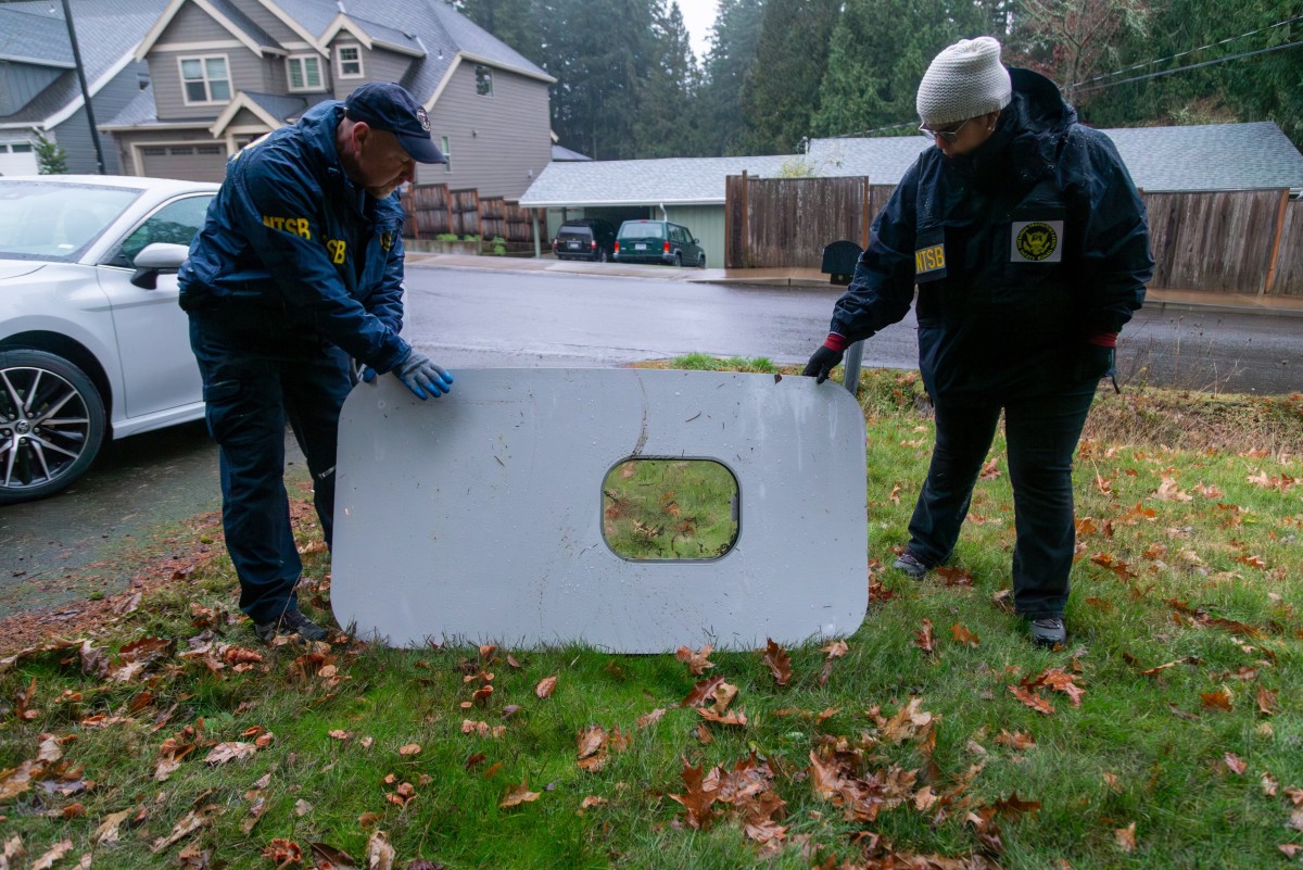 Cette image diffusée par le National Transportation Safety Board (NTSB) montre des agents inspectant le bouchon de porte du vol 1282 d'Alaska Airlines le 8 janvier 2024 après avoir été trouvé à Portland, dans l'Oregon. United Airlines a déclaré le 8 janvier qu'elle avait découvert des boulons desserrés sur des Boeing 737 MAX 9 de sa flotte lors d'inspections préliminaires suite à un incident en plein vol d'Alaska Airlines. Le 5 janvier, un avion de ligne d'Alaska Airlines a effectué un atterrissage d'urgence suite à l'explosion d'un bouchon de porte. (Photo par National Transportation Safety Board / AFP)