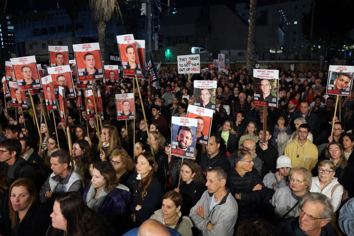 Des parents et des sympathisants tiennent des pancartes portant les portraits des otages israéliens détenus à Gaza depuis les attaques du 7 octobre par le Hamas dans le sud d'Israël, lors d'un rassemblement appelant à leur libération, à Tel Aviv, le 20 janvier 2023. (Photo Ahmad Gharabli AFP)