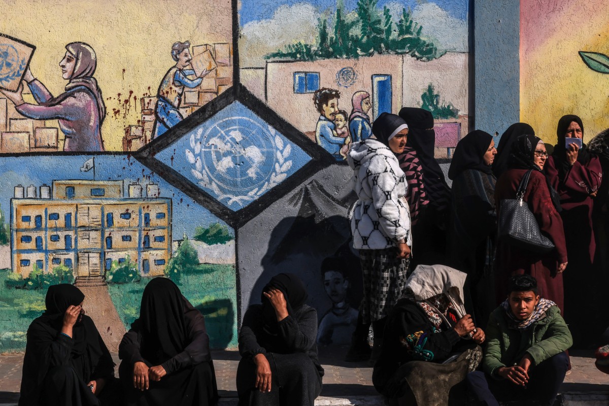 Des Palestiniens déplacés font la queue pour recevoir de l'aide devant le centre de l'Office de secours et de travaux des Nations Unies pour les réfugiés de Palestine (UNRWA) à Rafah, dans le sud de la bande de Gaza, le 28 janvier 2024, alors que les combats se poursuivent entre Israël et le Hamas. (Photo par AFP)