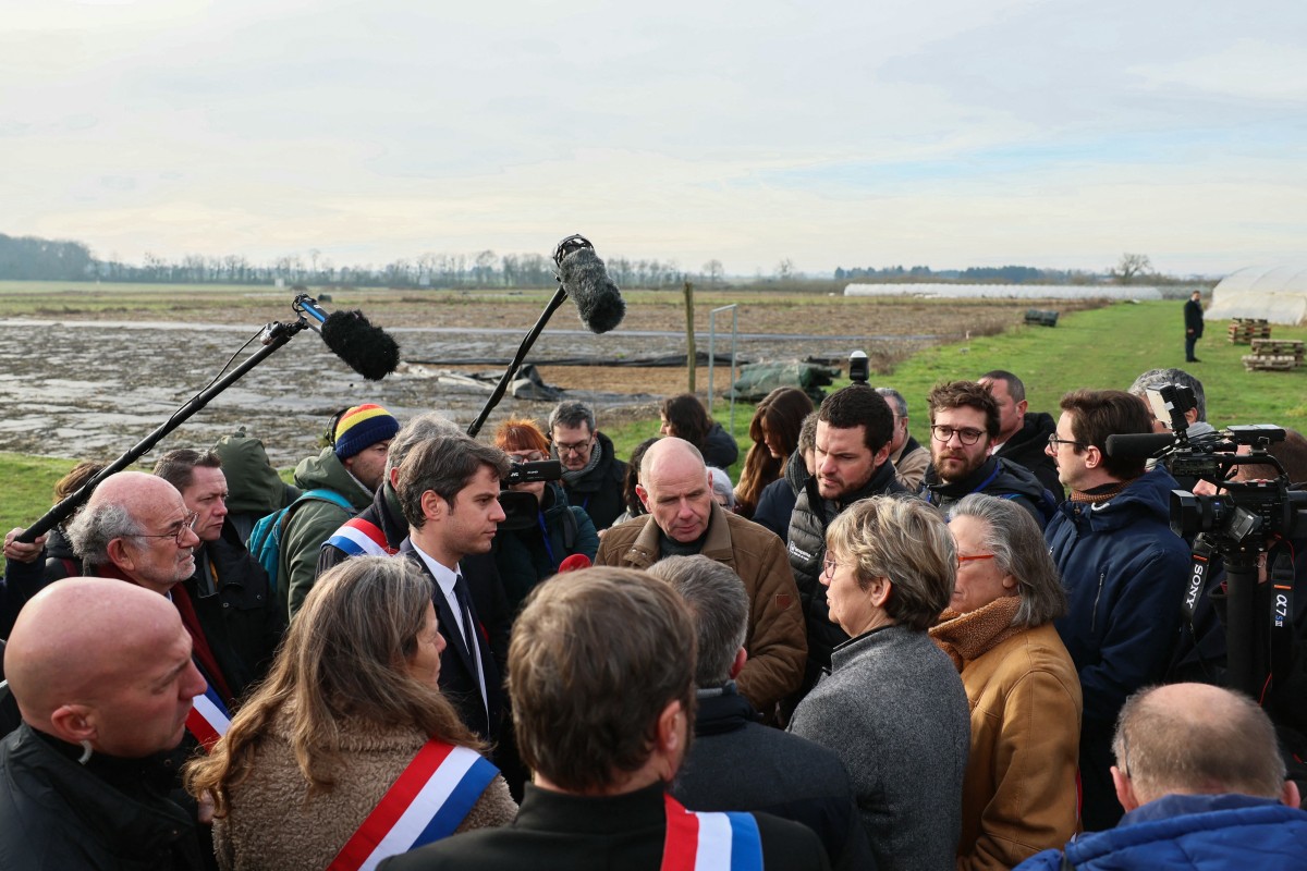 Le Premier ministre français Gabriel Attal (au centre) s'entretient avec des agriculteurs lors d'une visite dans une exploitation agricole à Parcay-Meslay, près de Tours, le 28 janvier 2024, dans un contexte de manifestations nationales organisées par plusieurs syndicats d'agriculteurs sur les salaires, les taxes et les réglementations. (Photo Alain Jocard / AFP)
