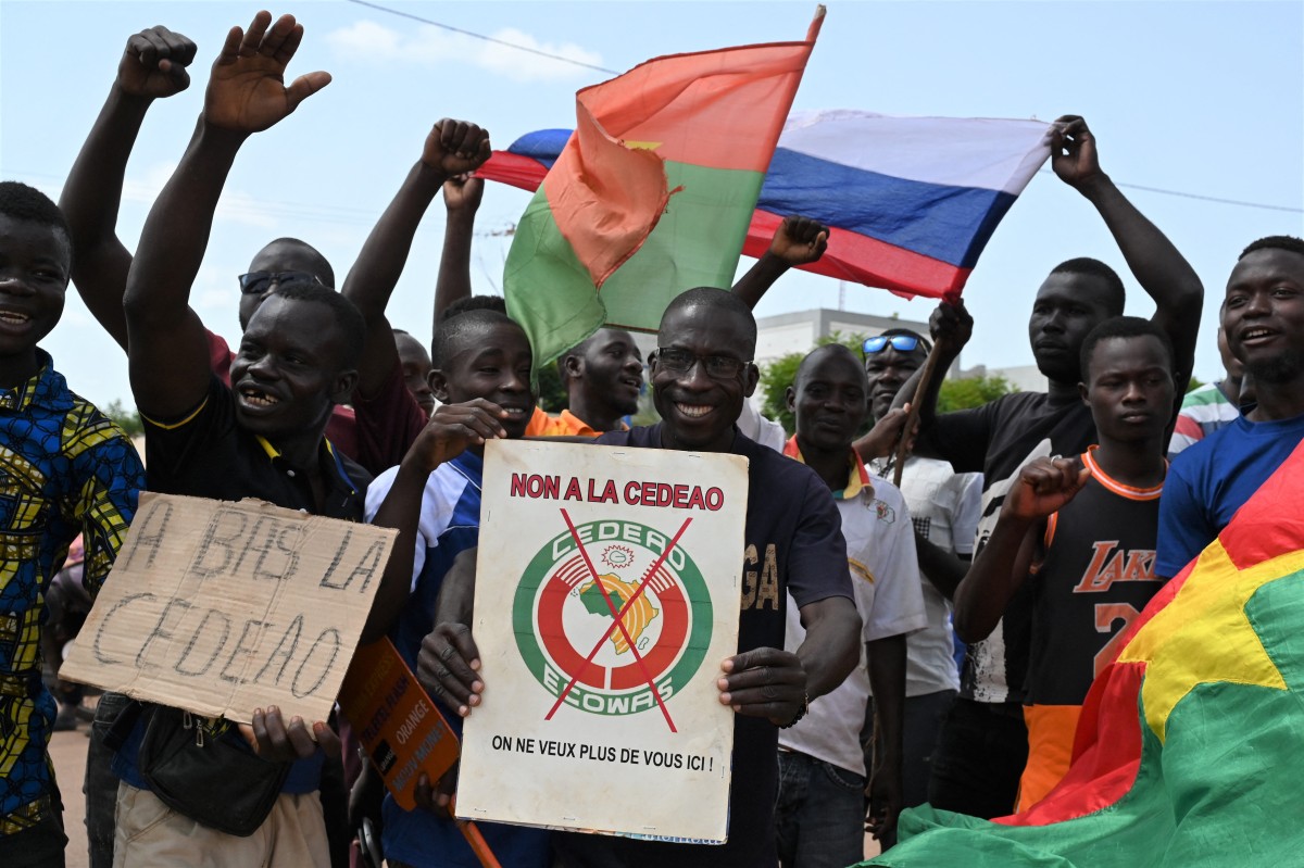 Un petit groupe de manifestants brandit des drapeaux russes et burkinabés pour protester contre la Communauté économique des États de l'Afrique de l'Ouest (CEDEAO), le 4 octobre 202 (Photo Issouf Sanogo AFP)