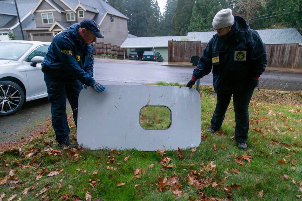 Cette image diffusée par le National Transportation Safety Board (NTSB) montre des agents inspectant le bouchon de porte du vol 1282 d'Alaska Airlines le 8 janvier 2024 après avoir été trouvé à Portland, dans l'Oregon. United Airlines a déclaré le 8 janvier qu'elle avait découvert des boulons desserrés sur des Boeing 737 MAX 9 de sa flotte lors d'inspections préliminaires suite à un incident en plein vol d'Alaska Airlines. Le 5 janvier, un avion de ligne d'Alaska Airlines a effectué un atterrissage d'urgence suite à l'explosion d'un bouchon de porte. (Photo par National Transportation Safety Board / AFP)