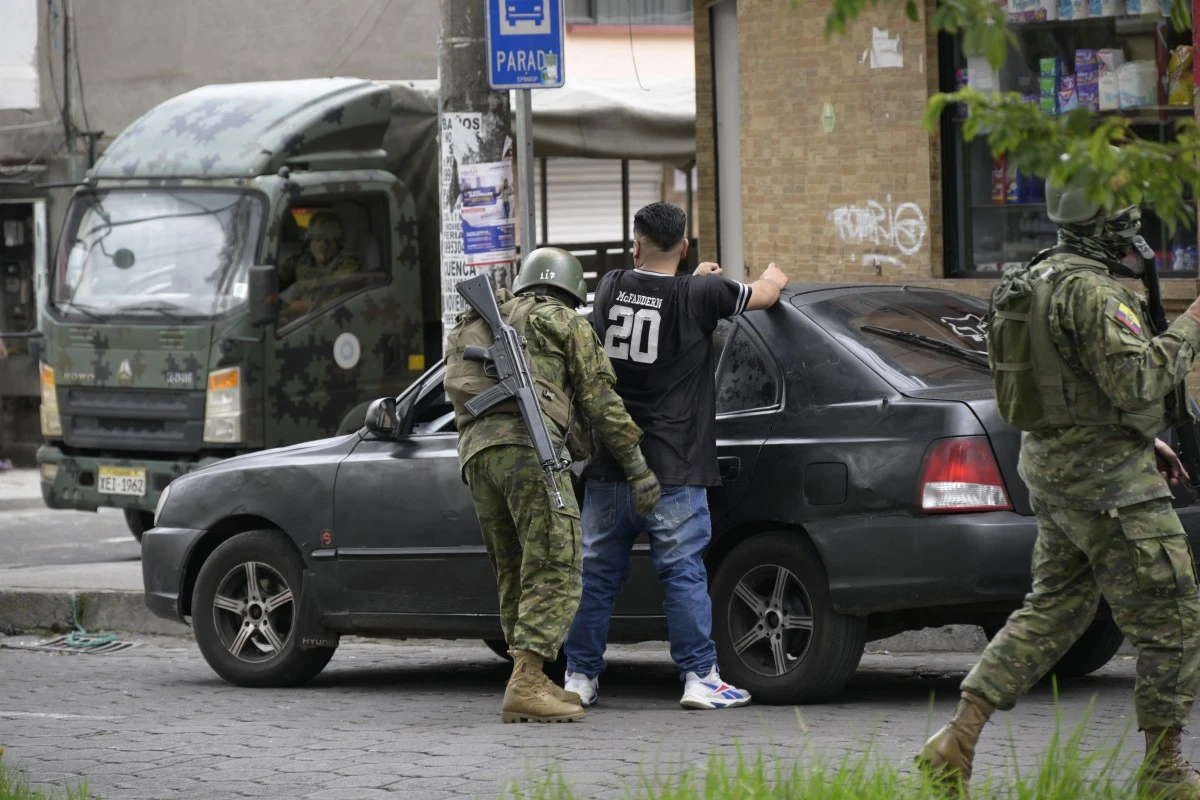 Un membre de l'armée interpelle un homme dans une rue de la zone Ciudadela del Ejercito, dans le sud de Quito, le 13 janvier 2024, alors que l'Équateur est en "état d'urgence" depuis l'évasion de prison de l'un des plus puissants narcotrafiquants du pays. (Photo Stringer AFP)