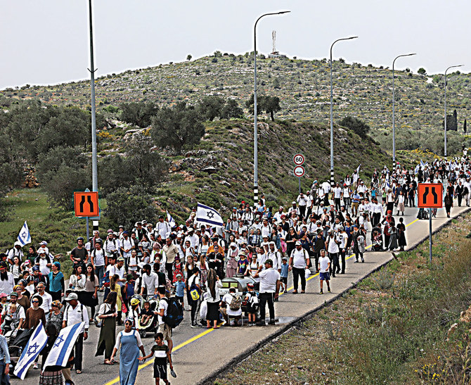 Des colons israéliens marchent vers l’avant-poste d’Eviatar, près du village palestinien de Beita, au sud de Naplouse, en Cisjordanie. (AFP)