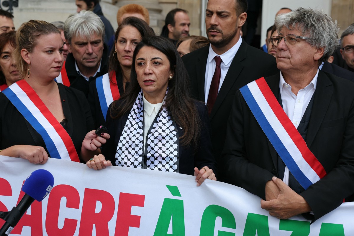 La représentante de l'Autorité palestinienne en France Hala Abou-Hassira (au centre) et la coalition de gauche NUPES - les députés du parti de gauche français La France Insoumise (LFI) Mathilde Panot (à gauche) et Eric Coquerel (à droite) se rassemblent à l'Assemblée nationale française à Paris le 7 novembre 2023, en tenant une banderole indiquant "Arrêtez le massacre à Gaza et en Cisjordanie, cessez le feu immédiatement". (Photo pThomas Samson AFP)