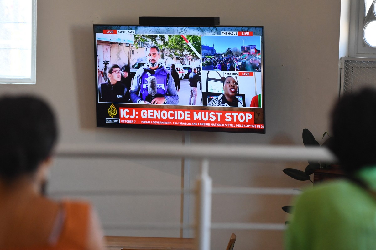Des personnes se rassemblent pour regarder la décision de la Cour internationale de justice (CIJ) dans l'affaire contre Israël intentée par l'Afrique du Sud à La Haye, à la Bertha House au Cap, le 26 janvier 2024. (Photo Rodger Bosch AFP)