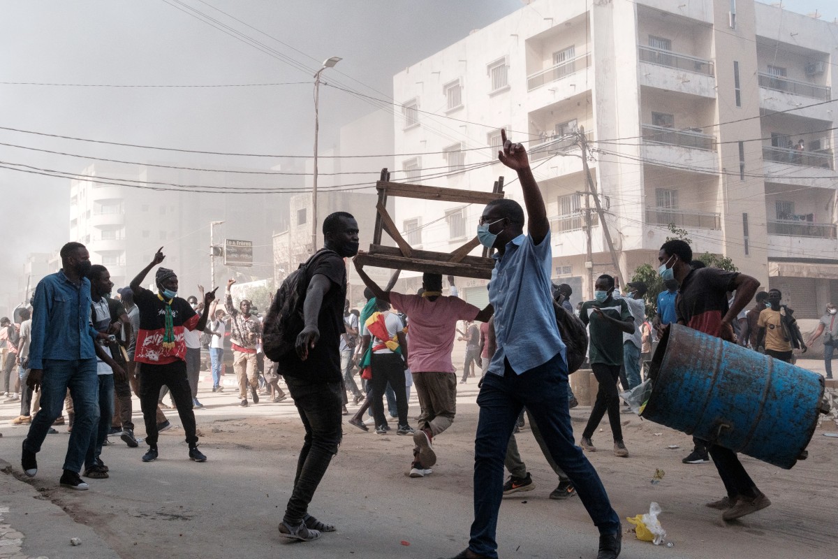 Des manifestants crient des slogans et ramassent des barils et des tables à brûler lors d'affrontements avec la police en marge d'une manifestation contre le report de dernière minute des élections présidentielles à Dakar, le 9 février 2024. (Photo Guy Peterson AFP)