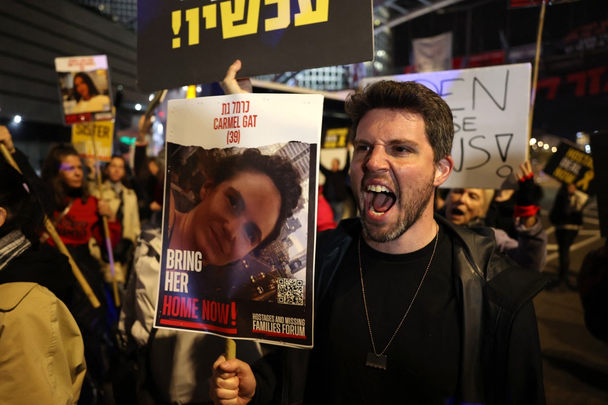 Un homme tient une pancarte portant le portrait de l'otage israélienne Carmel Gat, alors que des parents et des sympathisants des otages détenus à Gaza depuis les attaques du 7 octobre par les militants palestiniens du Hamas marchent lors d'une manifestation appelant à leur libération à Tel Aviv, le 15 février 2024. (Photo Ahmad Gharabli AFP)