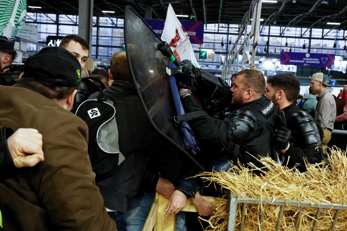 Des gendarmes se battent avec des agriculteurs rassemblés pour protester avant l'ouverture du 60e Salon international de l'agriculture, au parc des expositions de la Porte Versailles à Paris, le 24 février 2024. (Photo Kiran Ridley AFP)