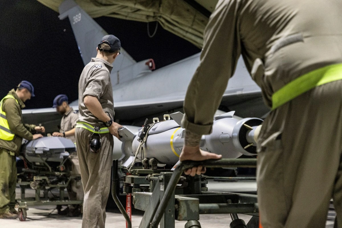 Une photo diffusée par le ministère britannique de la Défense (MOD) le 24 février 2024 montre un Typhoon FGR4 de la Royal Air Force dont les armes Paveway IV sont chargées par des techniciens d'armement à la RAF Akrotiri à Chypre, en préparation d'une frappe sur des cibles militaires au Yémen, le 22 février 2024.(Photo Tim Laurence MOD AFP)