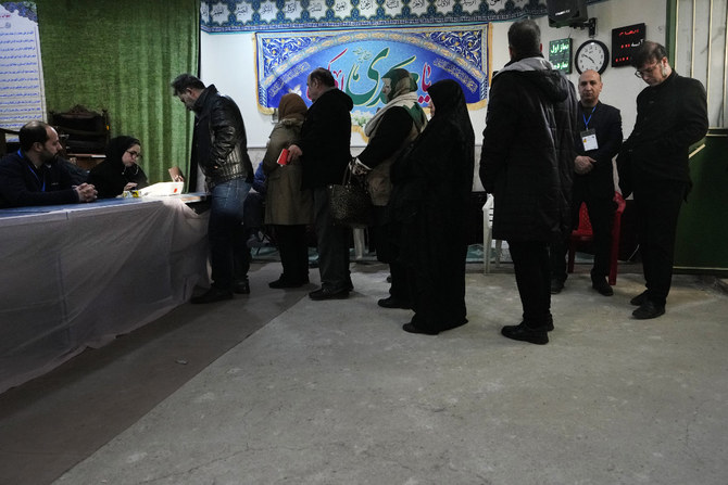 Des gens font la queue pour voter lors des élections législatives dans un bureau de vote à Téhéran, le 1er mars 2024 (AP Photo/Vahid Salemi).