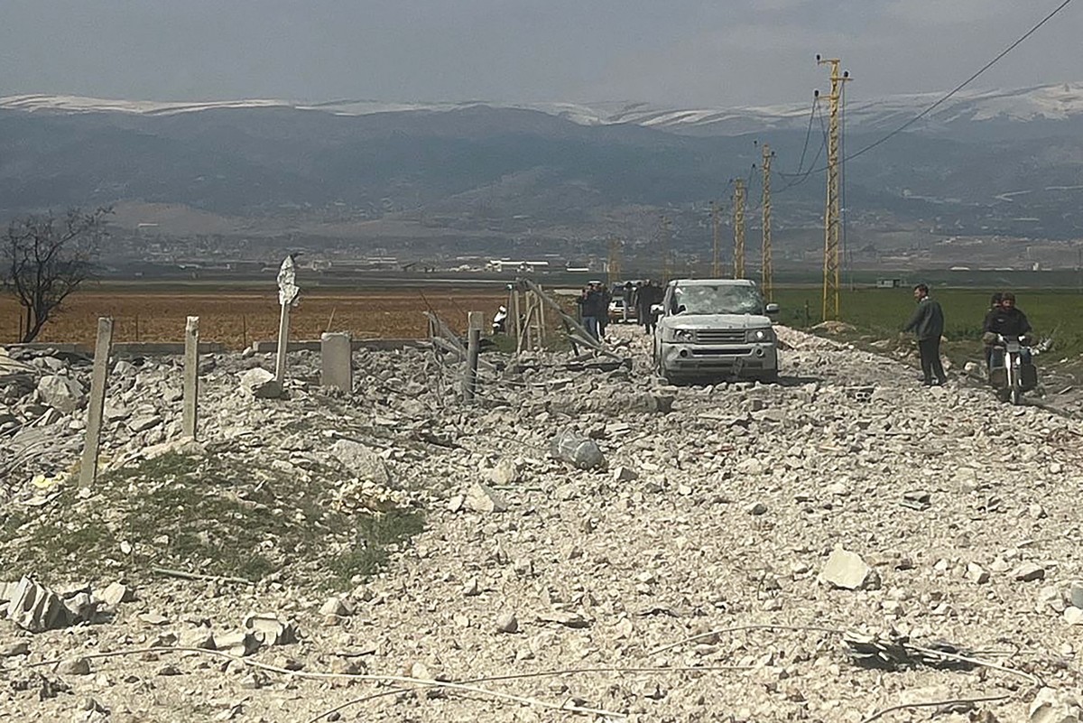 Des personnes se tiennent à côté des décombres sur le site d'une frappe aérienne israélienne dans les environs de la ville de Baalbek dans la plaine centrale de la Bekaa le 26 février 2024. (Photo AFP)