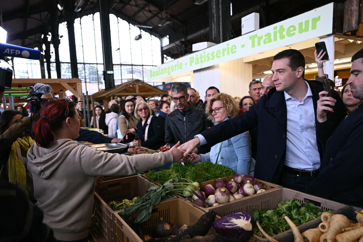 Le président du Rassemblement national (RN) et chef de file de la liste électorale, Jordan Bardella (à droite) visite un marché à Belfort, dans l'est de la France, dans le cadre de sa campagne pour les prochaines élections européennes, le 23 mars 2024. (Photo par Sebastien Bozon AFP)