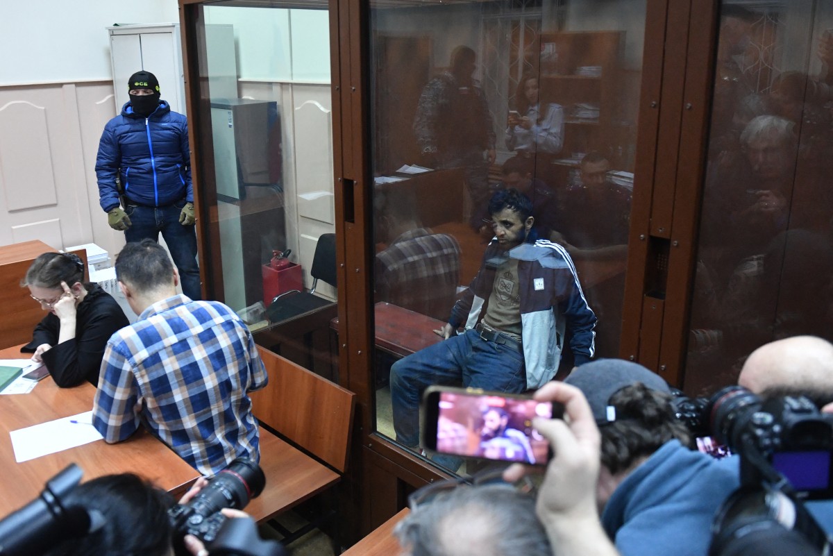 Dalerdjon Barotovich Mirzoyev soupçonné d'avoir participé à l'attaque d'une salle de concert qui a fait 137 morts, l'attentat le plus meurtrier en Europe revendiqué par le groupe jihadiste État islamique, est assis dans la cage des accusés alors qu'il attend son audience de détention provisoire au tribunal du district de Basmanny à Moscou, le 24 mars 2024. (Photo d'Olga Maltseva AFP)