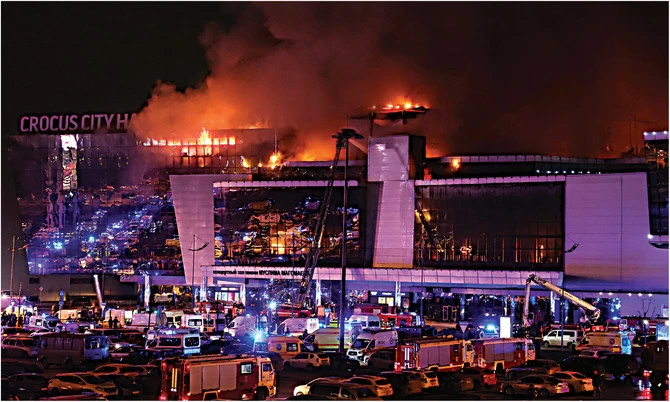 Des ambulances et des véhicules des services d'urgence russes sont garés dans la salle de concert Crocus City Hall en flammes à la suite d'une fusillade, à l'extérieur de Moscou, le 22 mars 2024. (REUTERS)