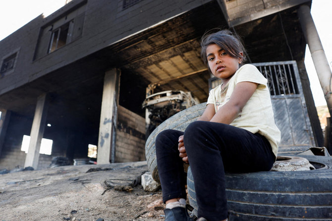 Une fillette palestinienne assise devant sa maison après l'attaque du village d'Al-Mughayyer par des colons israéliens, en Cisjordanie occupée par Israël. (REUTERS)