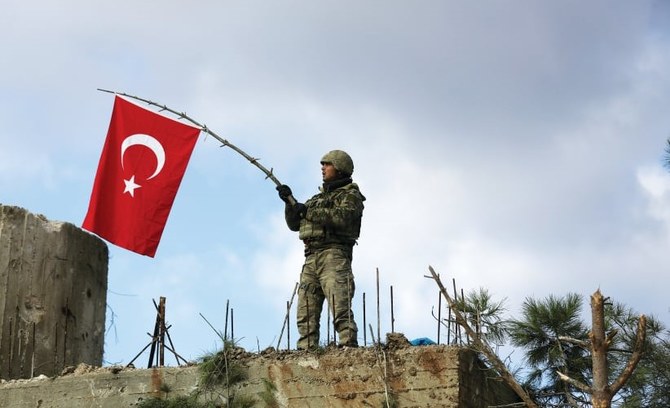 Un soldat turc agite le drapeau national sur le mont Barsaya, au nord-est d’Afrin, en Syrie, en janvier 2018. (Reuters)