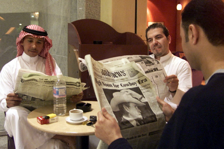 Des Saoudiens lisent le 19 mars 2003 les journaux locaux en prenant un café au Starbucks du centre commercial Kingdom Tower, à Riyad. (Photo Bilal Qabalan / AFP)