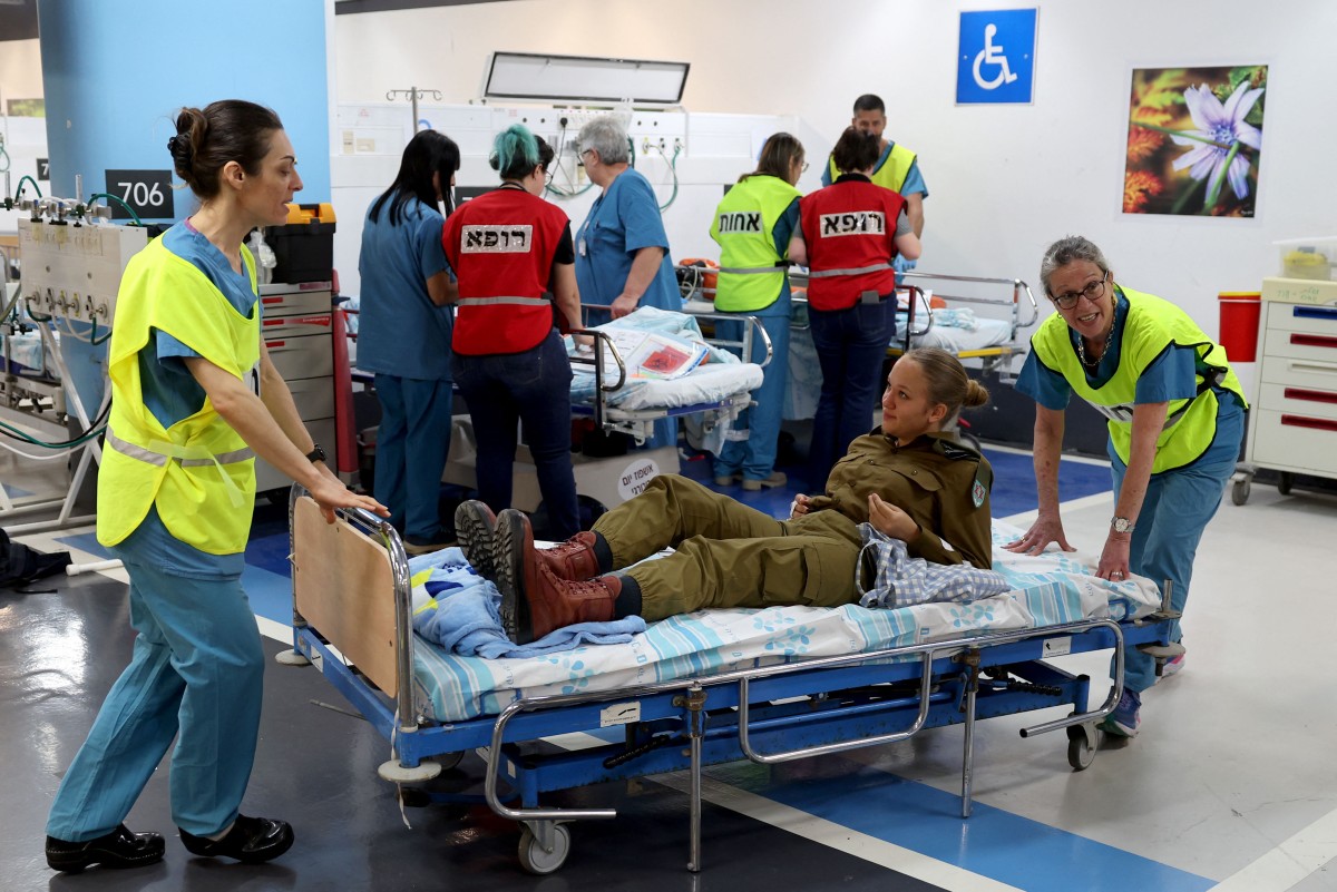 Du personnel médical israélien et un soldat participent à un exercice de simulation dans un parking qui peut être transformé en hôpital souterrain d'urgence, au Rambam Health Care Campus, dans la ville de Haïfa, au nord d'Israël, le 18 avril 2024. (Photo Jack Guez AFP)