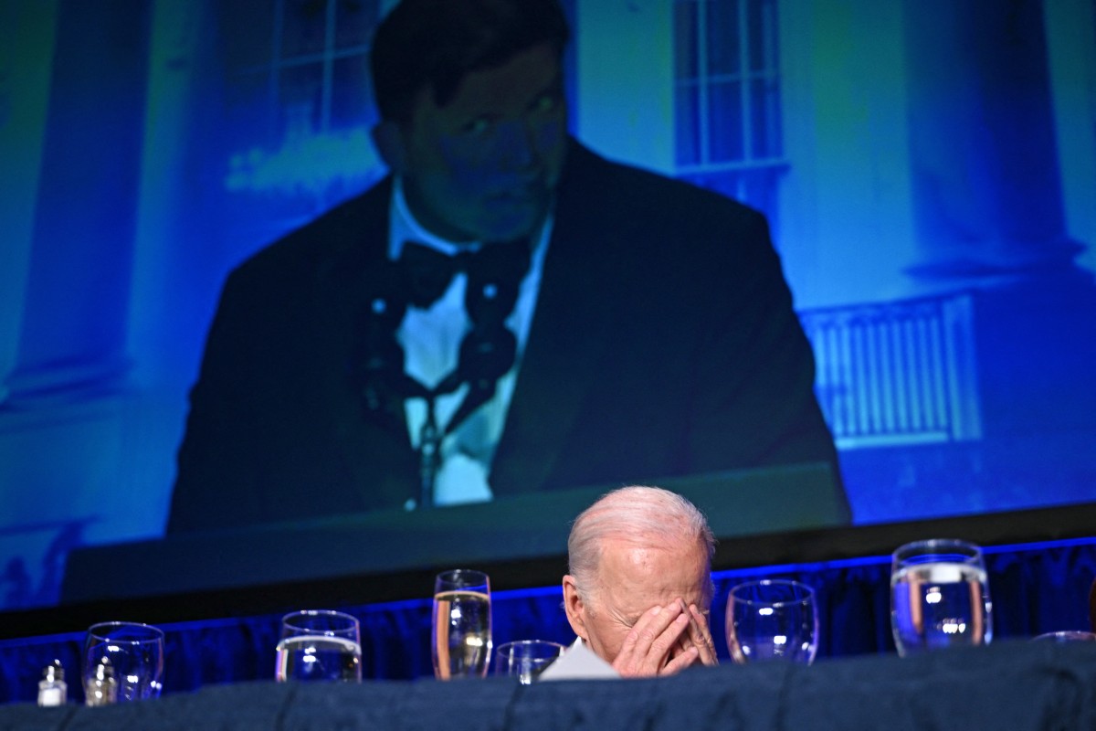 Le président américain Joe Biden rit pendant que l'humoriste américain Colin Jost (à l’écran) prend la parole lors du dîner de l'Association des correspondants de la Maison Blanche (WHCA) au Washington Hilton, à Washington, DC, le 27 avril 2024. (Photo par Brendan Smialowski AFP)