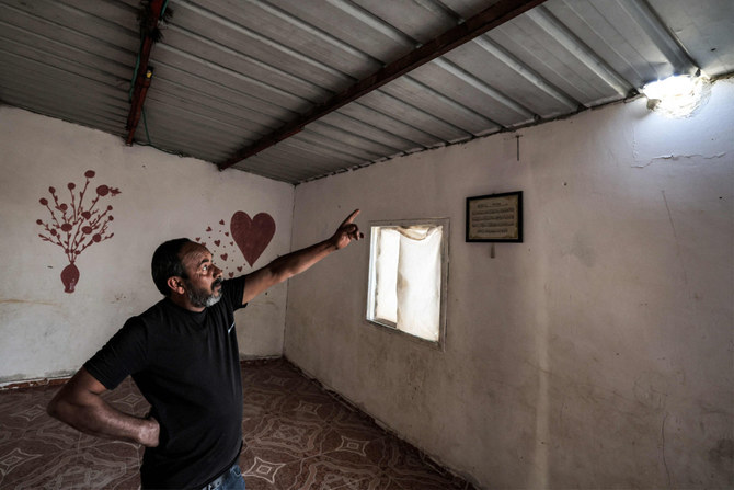 Mohammed Hassouna montre un trou causé par un projectile qui a blessé sa fille Amina dans leur maison du désert du Néguev. (AFP)