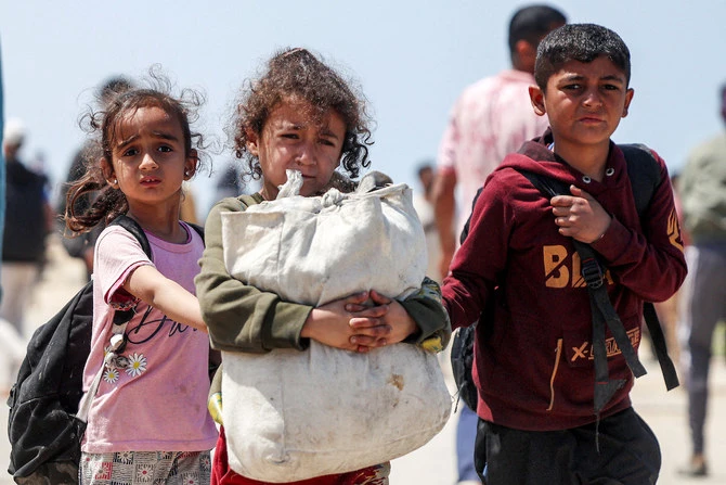 Des enfants marchent avec d’autres Palestiniens déplacés qui empruntent la route côtière de Rachid pour retourner dans la ville de Gaza, en passant par le camp de Nuseirat, dans le centre de la bande de Gaza. (Photo, AFP)
