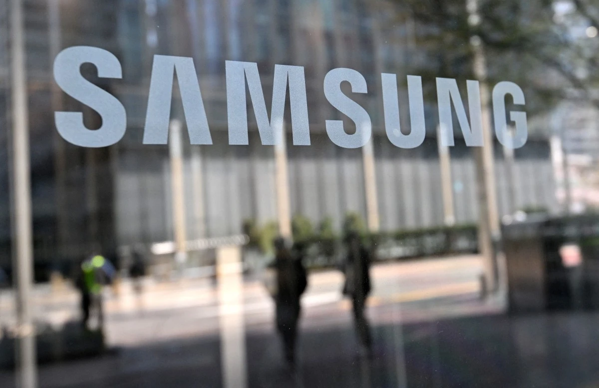 Des personnes passent devant le logo Samsung affiché sur une porte en verre dans le bâtiment Seocho de la société à Séoul, le 5 avril 2024. (Photo Jung Yeon-je / AFP)