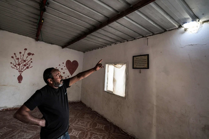 Mohammed Hassouna montre un trou causé par un projectile qui a blessé sa fille Amina dans leur maison du désert du Néguev. (AFP)