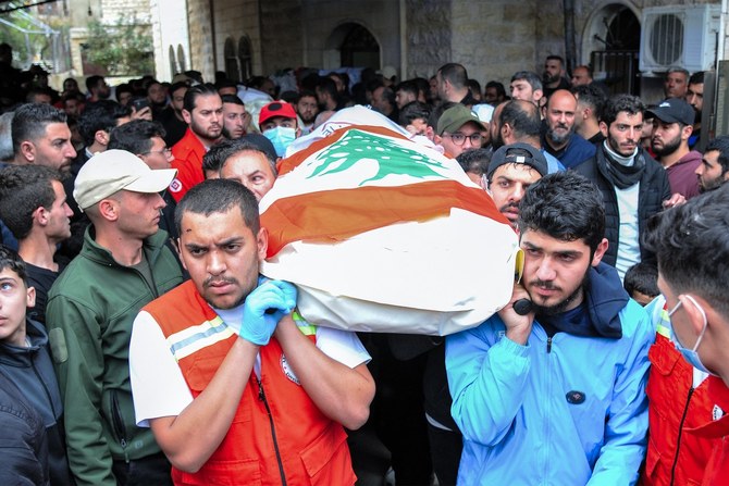 Des personnes et des membres de l'ONG libanaise Emergency and Relief Corps portent le corps d'une des victimes tuées lors d'un bombardement israélien, pendant les funérailles dans le village de Habariyeh au sud du Liban, le 27 mars 2024 (AFP).