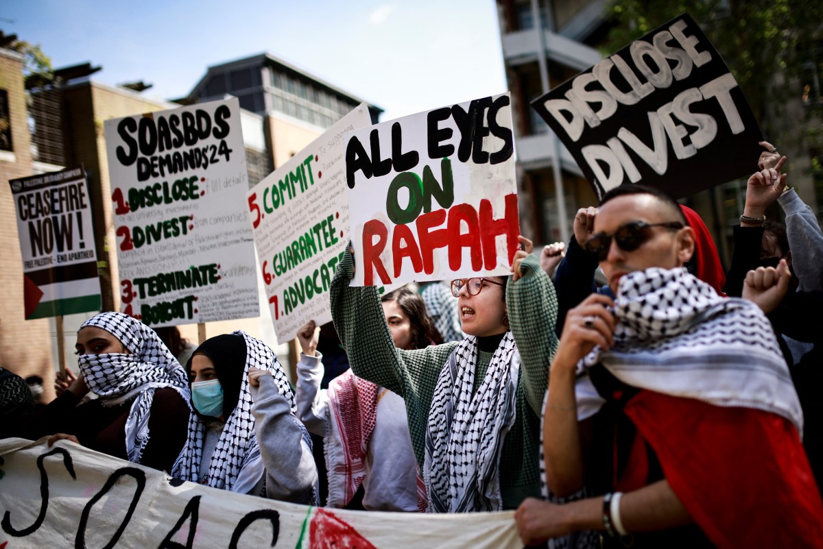 Des étudiants tiennent des pancartes et scandent des slogans lors d'un rassemblement dans un camp pro-palestinien installé sur le campus de la School of Oriental and African Studies (SOAS) à Londres, le 8 mai 2024. (Photo par Benjamin Cremel AFP)
