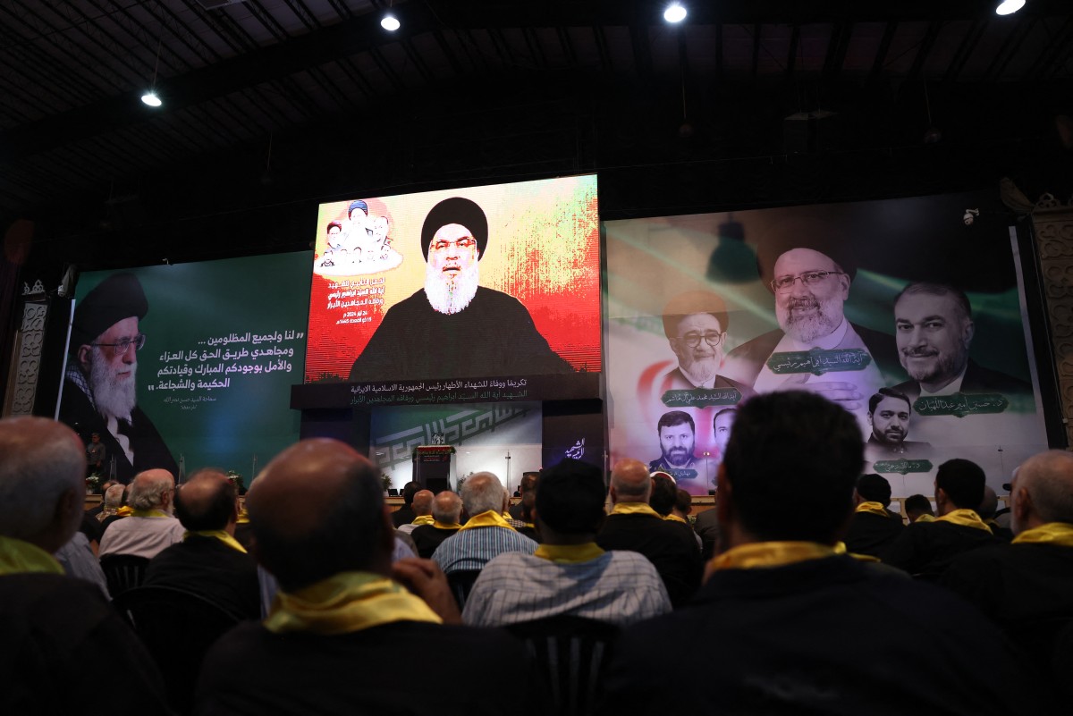 Des personnes se rassemblent pour écouter un discours télévisé du secrétaire général du Hezbollah libanais, Hassan Nasrallah, lors d'un rassemblement pour pleurer la mort récente du président iranien Ebrahim Raisi et de son entourage, tués dans un récent accident d'hélicoptère, dans la banlieue sud de Beyrouth, le 24 mai 2024. (Photo Anwar Amro AFP)