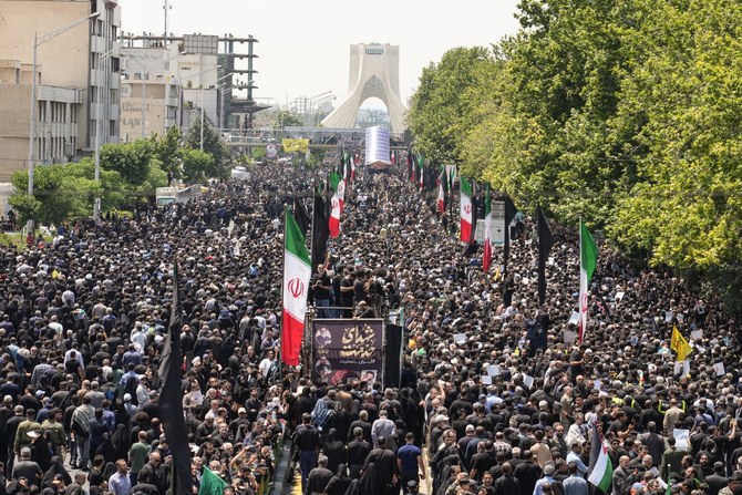 Des personnes assistent au cortège funèbre du président iranien, Ebrahim Raïssi, à Téhéran, le 22 mai 2024. (AFP)
