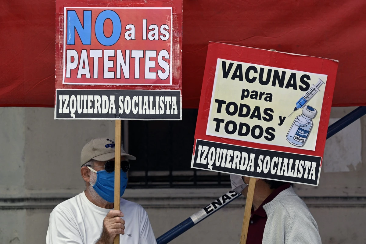Des personnes brandissent des banderoles sur lesquelles on peut lire "Des vaccins pour tous" et "Non aux brevets" lors d'une manifestation de membres de partis de gauche devant le siège de l'Organisation mondiale de la santé (OMS) à Buenos Aires, le 14 avril 2021, dans le contexte de la pandémie de coronavirus. (photo Juan Mabromata, AFP)