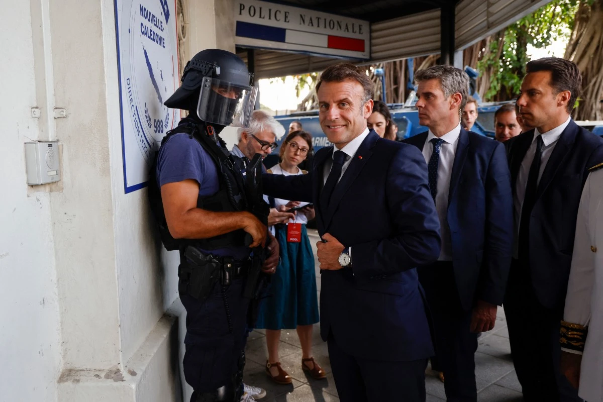 Le président français Emmanuel Macron (C) arrive au commissariat central de Nouméa, territoire français de Nouvelle-Calédonie dans le Pacifique, le 23 mai 2024. (Photo Ludovic Marin POOL AFP)