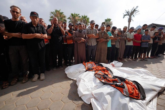 Ci-dessus, des personnes en deuil se recueillent devant les corps de quatre volontaires de la défense civile tués lors du bombardement israélien du camp de réfugiés de Nuseirat, le 28 juin 2024. (AFP)