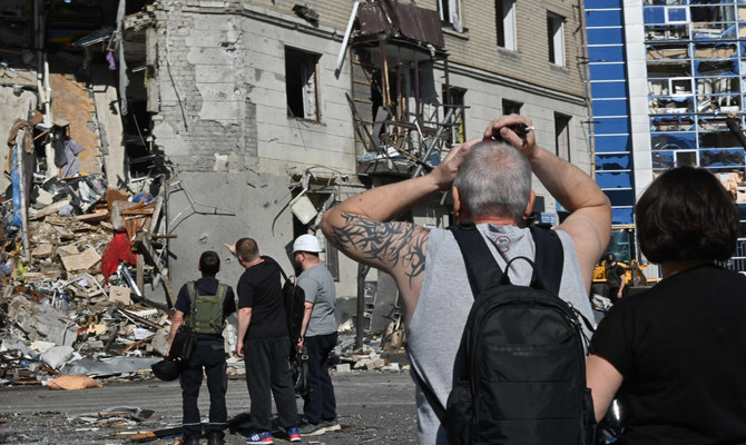 Réaction des habitants près d'un immeuble résidentiel détruit par l'explosion d'une bombe aérienne dans le centre de Kharkiv. (AFP)