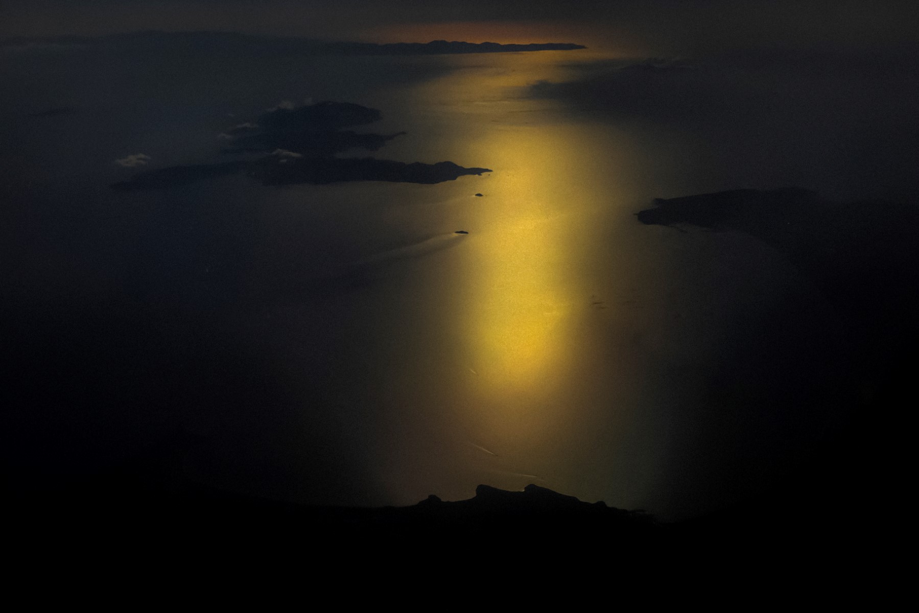 Cette photographie prise depuis un avion de ligne le 11 juillet 2021 montre une vue aérienne de l'île d'Elbe (en haut à gauche) dans la mer Tyrrhénienne au large de la ville côtière de Piombino (à droite) en Toscane, en Italie, et de la pointe de l'île française de Corse (à l'arrière). (Photo Laurent Emmanuel AFP)